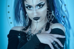 Image title : Gigi. A fantasy portrait  of a young woman held in blue tones. The woman are wearing black and white face paint and makeup. her clothes are black and she has long black hair with purple stands in it.All made with Adobe Photoshop . Images and textures provided by Caroline Julia Moore.